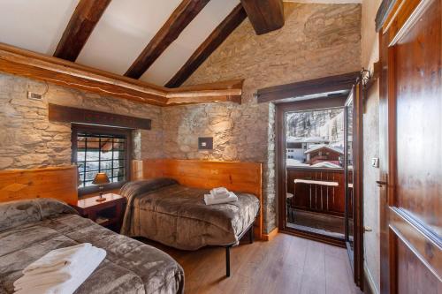a bedroom with two beds and a window at Arthemisia - Rhêmes-Notre-Dame in Rhêmes-Notre-Dame