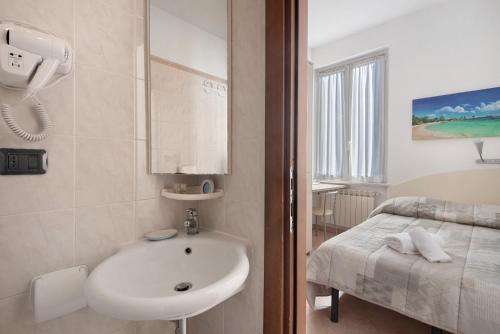 a bathroom with a sink and a bed at Affittacamere Monica in Levanto