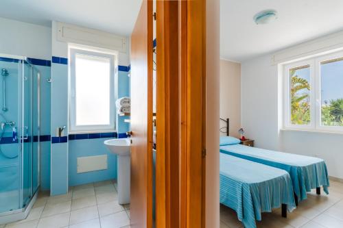 a bathroom with a bed and a shower and a sink at Residence Punta Pizzo in Marina di Mancaversa