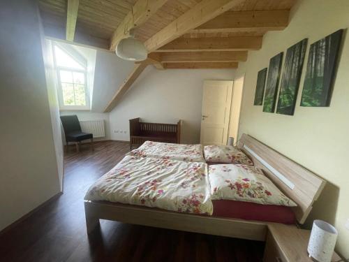 a bedroom with a bed and a chair in it at Ferienwohnungen Fischbachhof in Sulzbach an der Murr