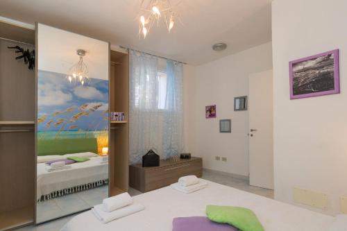 a bedroom with a bed and a painting on the wall at Castiglioncello Mare Apartment in Castiglioncello