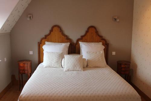 a bedroom with a bed with white sheets and pillows at Au p'tit Mont in Ardevon