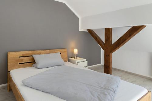 a bedroom with a white bed and a tree at Ferienhaus in Zernitz