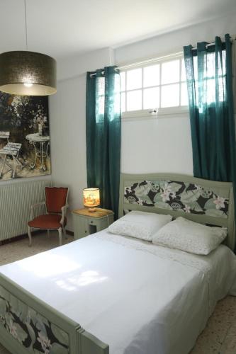 a bedroom with a large white bed with blue curtains at Villa Loudéro in Bédarieux
