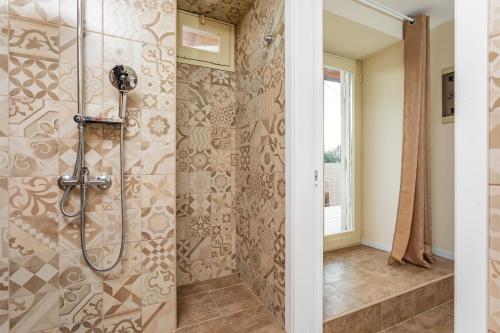 a bathroom with a shower with a glass door at Pètra Janca in Aci SantʼAntonio