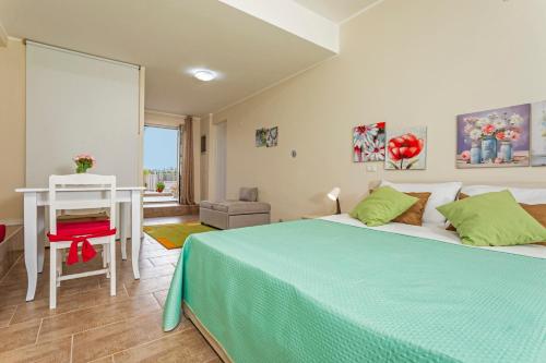 a bedroom with a bed and a table and a desk at Pètra Janca in Aci SantʼAntonio