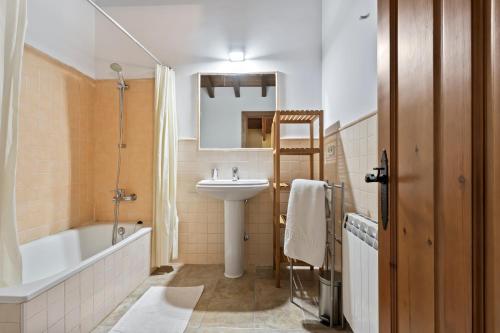 a bathroom with a sink and a toilet and a tub and a mirror at La Ceriquina in Nava