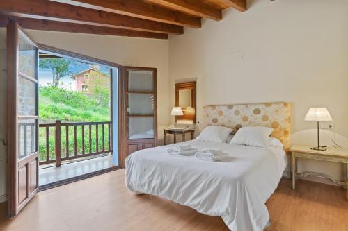 a bedroom with a large bed and a balcony at La Ceriquina in Nava