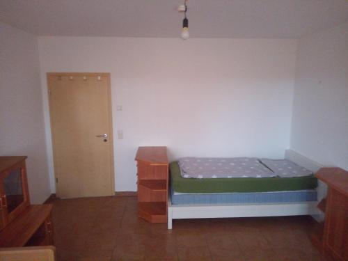 una piccola camera da letto con un letto e una porta di Beier a Neustrelitz