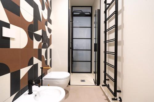 a bathroom with a toilet and two sinks at Dimora Màufra in Locorotondo