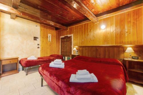 two beds in a room with wooden walls at Arthemisia - Rhêmes-Notre-Dame in Rhêmes-Notre-Dame
