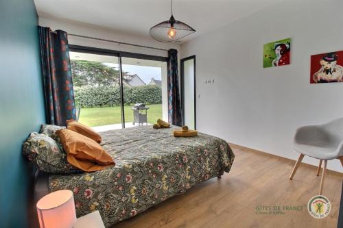 a bedroom with a bed and a large window at Ty mam goz in Trébeurden