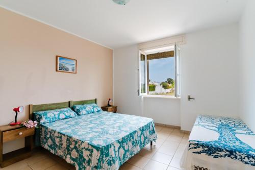 a bedroom with a bed and a window at Residence Punta Pizzo in Marina di Mancaversa
