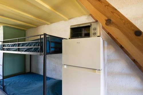a dorm room with a refrigerator and a bunk bed at Le Cinque in Appietto