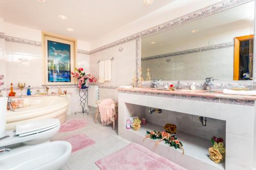 a bathroom with a tub and a sink and a toilet at Villetta Mare e Monti in Mascali