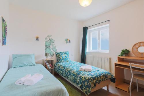 a bedroom with a bed and a desk and a window at Oasis tropicale a Cleguerec in Cléguérec