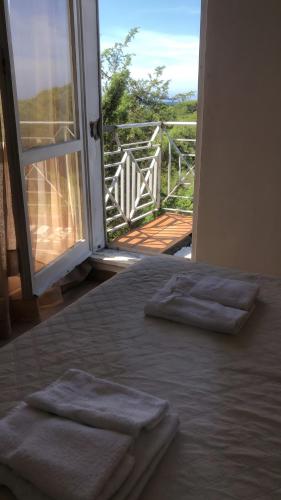 a bed with three towels on it with an open door at Casa Nessi- Stanze in Platamona