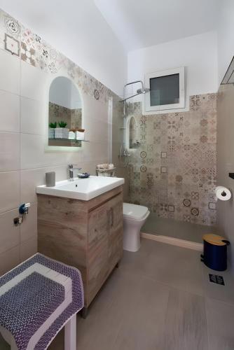 a bathroom with a sink and a toilet and a tv at Maestro Apartment 2 in Vlachopoulátika