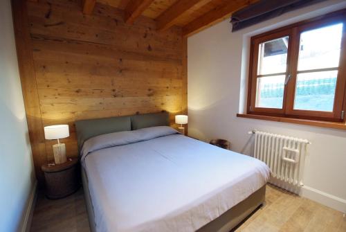 a bedroom with a white bed and a window at Villaggio delle Alpi in Pré-Saint-Didier