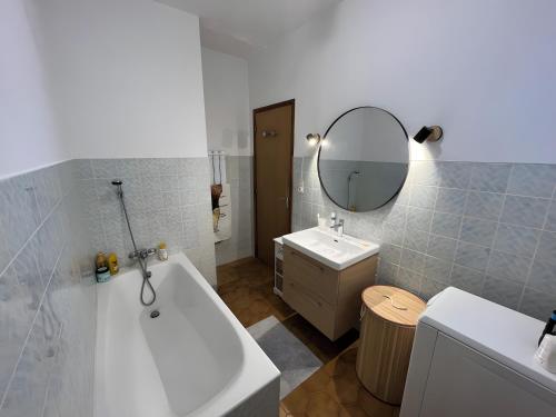 a bathroom with a tub and a sink and a mirror at Maison Corsica vue mer exceptionnel in Cervione