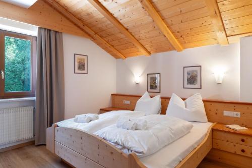 a bedroom with a large bed with white sheets at Aldeinerhof in Aldino