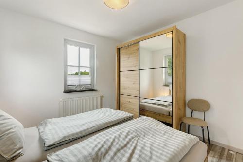 a bedroom with a bed and a mirror at Chalet Sonnenhügel in Schmallenberg