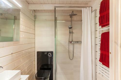 a shower with a glass door in a bathroom at Sundowner Cabin in Oberammergau