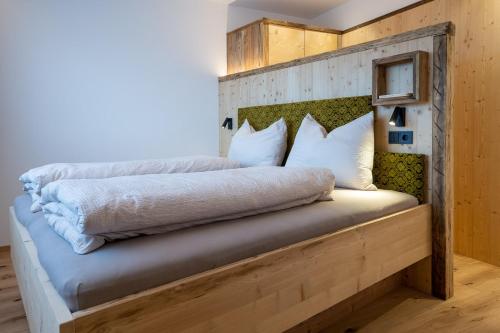 a bed with white sheets and pillows on it at Ladinser Hof Sternenhimmel in Castelrotto