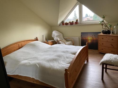 a bedroom with a bed and a window and a chair at Im schönen Garten in Haldensleben