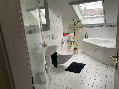 a bathroom with a sink and a tub and a toilet at Im schönen Garten in Haldensleben