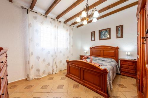 a bedroom with a wooden bed and a window at La Tierra in Níjar