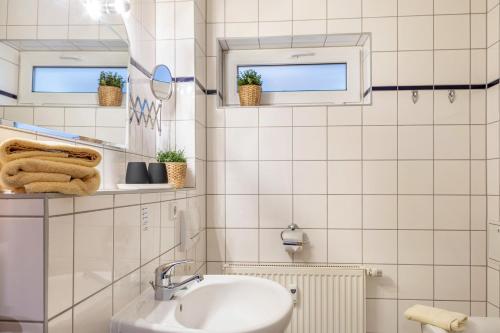 a white bathroom with a sink and two windows at Ferienwohnung Tannenblick 2-1 in Oberhof