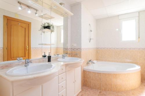 a bathroom with two sinks and a large mirror at Chalet Limonita in Mutxamel