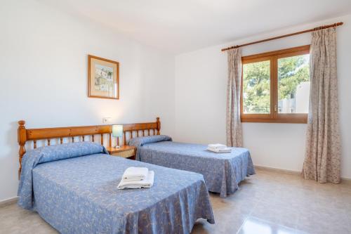 a hotel room with two beds and a window at Apartamentos Karin 1ºa in Cala d´Or