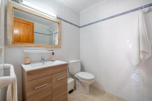 a bathroom with a toilet and a sink and a mirror at Apartamentos Karin 1ºa in Cala d´Or