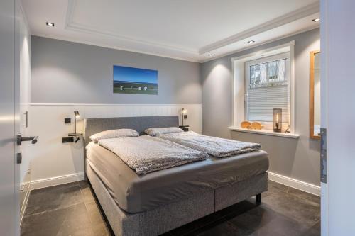 a bedroom with a bed and a window at Kleine Auszeit in Dagebüll