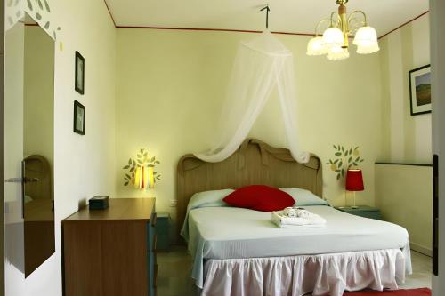 a bedroom with a bed with a red pillow at Agriturismo Debbione Maro' in Suvereto