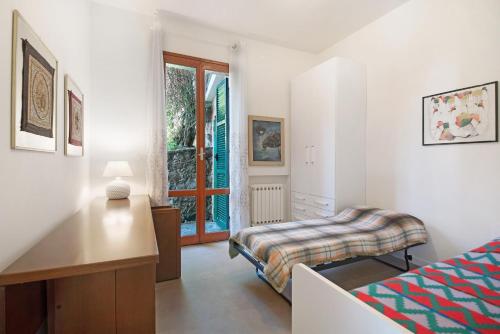 a bedroom with a bed and a desk and a window at Villa Del Sole in Bonassola