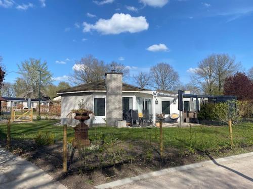 a white house with a fence in front of it at HOLTINGERHUYS Havelte- Giethoorn! Tegen betaling Wellness!!! in Havelte