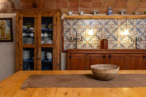 a dining room with a china cabinet and a bowl on a table at Casa rural siglo xviii in Pals