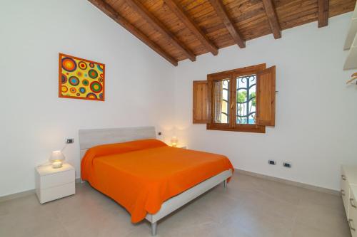 a bedroom with a orange bed and a window at San Teodoro Villa Ambra Costa Caddu in San Teodoro