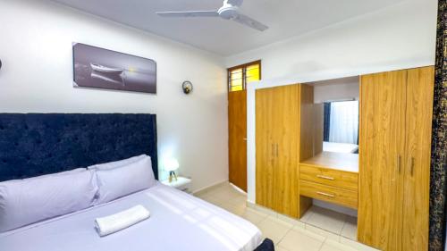 a bedroom with a bed and a tv on the wall at Diani Hideouts 2 in Kwale