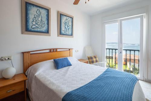 a bedroom with a bed and a view of the ocean at Primera línea de playa Cabo Cruz in Boiro