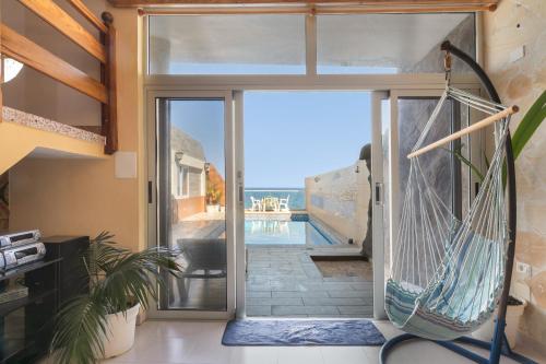 a glass door leading to a patio with a hammock at Seaside House With Heated Pool in Pájara