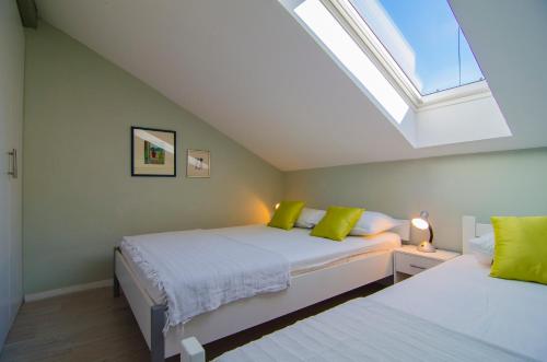 sypialnia na poddaszu z 2 łóżkami i świetlikiem w obiekcie Maestro Duplex Istarska Apartment w Splicie
