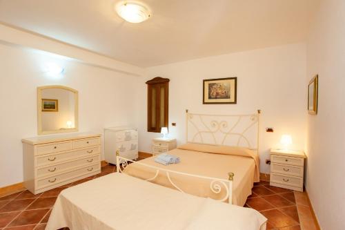 a bedroom with two beds and a mirror at Appartamento Paguro in Cala Liberotto