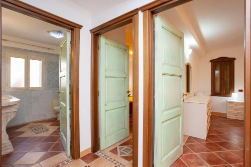 a bathroom with green doors and a tile floor at Appartamento Paguro in Cala Liberotto
