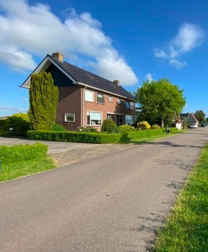 a house sitting on the side of a road at Huis bij het water in uitstekend fiets-, vis- en vaargebied in Jutrijp