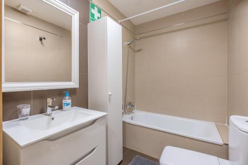 a bathroom with a sink and a tub and a toilet at Ágora Alhambra in Atarfe