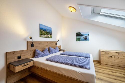 a bedroom with a large bed with blue pillows at Fewo Brünnstein - Zimmer 50 in Oberaudorf